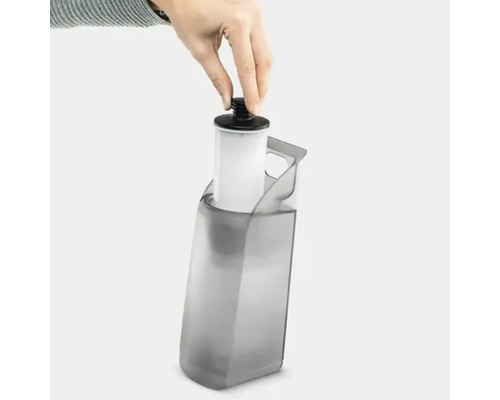 Une main place un filtre à eau dans un réservoir d''eau.