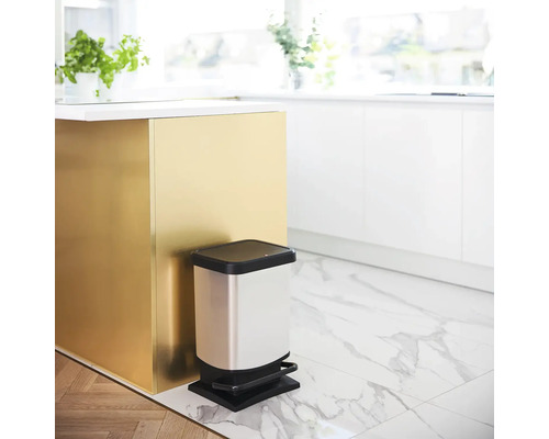 Poubelle métallique à pédale dans une cuisine claire.