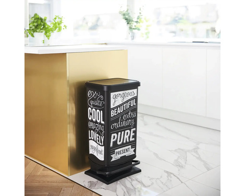 Schwarzer Tretabfalleimer mit weißer Aufschrift in einer Küche