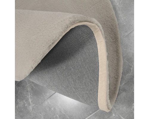 Vue détaillée d''un tapis avec surface à poils et dos en textile.