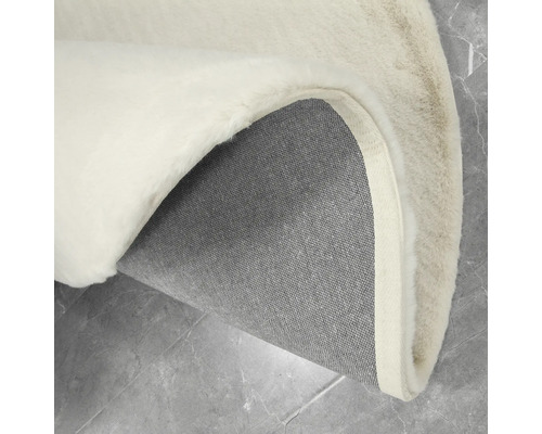 Vue détaillée d''un tapis rond à poils longs avec un dos tissé