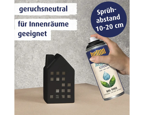 Eine Hand sprüht mit Helton Farbspray eine kleine Häuserdekoration an. Farbspray ist geruchsneutral und für Innenräume geeignet. Sprühabstand beträgt 10 bis 20 cm.