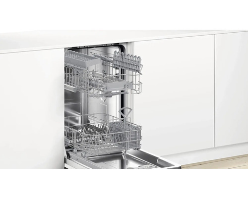 Lave-vaisselle ouvert avec paniers à couverts dans une cuisine équipée blanche
