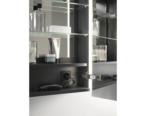 Armoire de toilette ouverte avec étagères en verre, prise de courant et accessoires de salle de bain