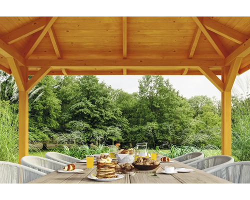 Pavillon en bois avec table dressée dans le jardin