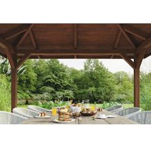 Gedeckter Tisch unter einem Holzpavillon mit Blick in den Garten