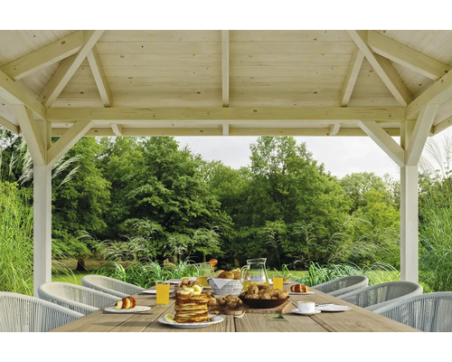 Pavillon de jardin en bois avec table dressée et vue sur le jardin