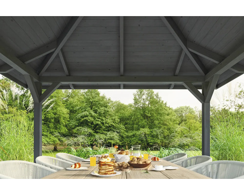 Holzpavillon mit Esstisch und Gartenblick