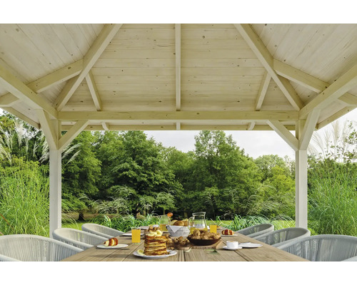 Pavillon de jardin en bois avec table dressée et chaises dans le jardin