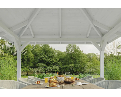 Pavillon blanc avec table dressée et vue sur le jardin