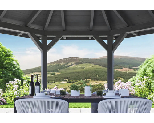 Pavillon de jardin en bois avec table dressée et vue sur un paysage de collines