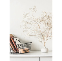 Scène décorative avec panier de rangement, carnets et fleurs séchées dans un vase sur une commode