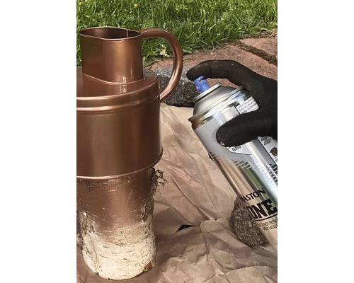 Eine Person sprüht einen Krug mit einer Sprühdose.