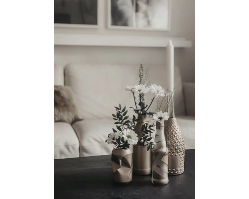 Scène de table décorative avec des fleurs dans des vases devant un canapé