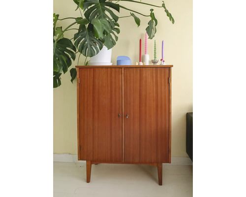 Armoire en bois à deux portes et quatre pieds, ornée d''une plante d''intérieur et de bougies