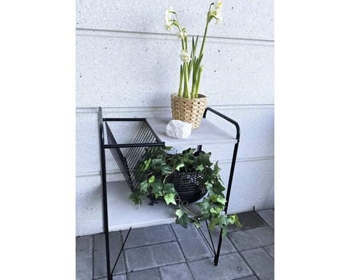 Table d''appoint décorative avec deux étagères, décorations florales et collection de magazines pour l''intérieur.