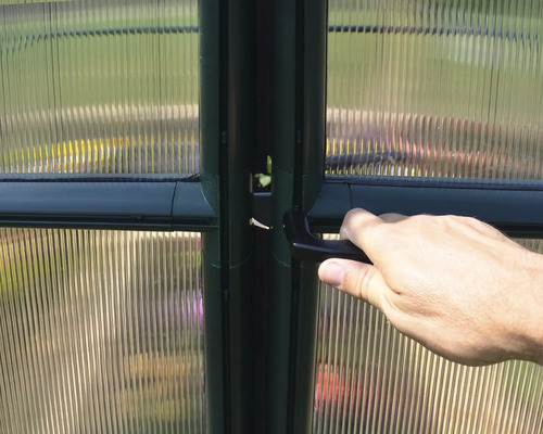 Detailaufnahme einer Gewächshaustür mit Griff und Polycarbonatplatten