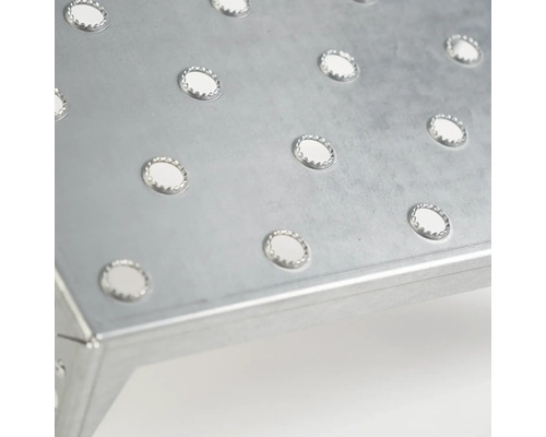 Vue détaillée d''une surface de marche en métal avec des trous pour une meilleure adhérence.