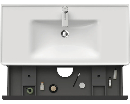 Meuble-lavabo avec tiroir ouvert et accessoires de salle de bain placés à l''intérieur