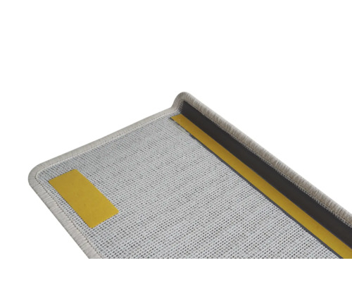 Detailansicht einer grauen Treppenstufe mit Klebestreifen zur Befestigung.