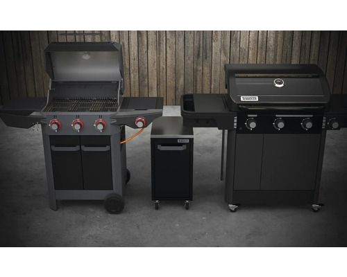 Deux barbecues et une armoire de barbecue de la marque Tenneker devant un mur en bois.