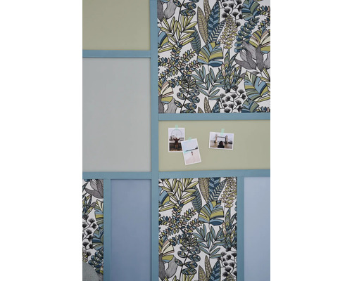 Décoration murale avec papier peint botanique, photos et cadres bleu clair