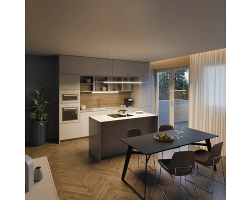 Heller Raum mit Einbauküche, Kochinsel, Esstisch und Stühlen