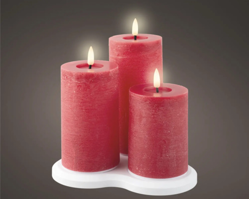Trois bougies piliers rouges de différentes hauteurs sur un support blanc