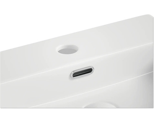 Detailansicht eines Waschbeckens mit Hahnloch und Überlauf