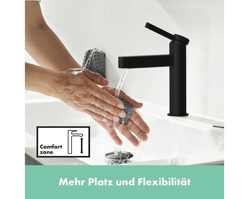 Waschbeckenarmatur in Schwarz mit Wasserstrahl und Händen unter dem laufenden Wasserhahn