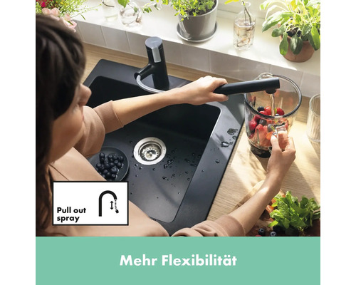 Femme remplissant un pichet sous un robinet de cuisine avec douchette extractible