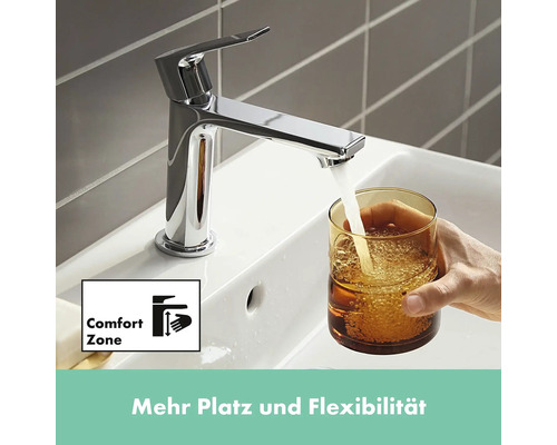 Chrom-Wasserhahn füllt ein Glas Wasser in einem Waschbecken