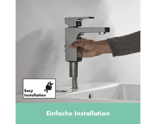 Person installiert einen verchromten Wasserhahn auf einem Waschbecken. Symbol für einfache Installation.