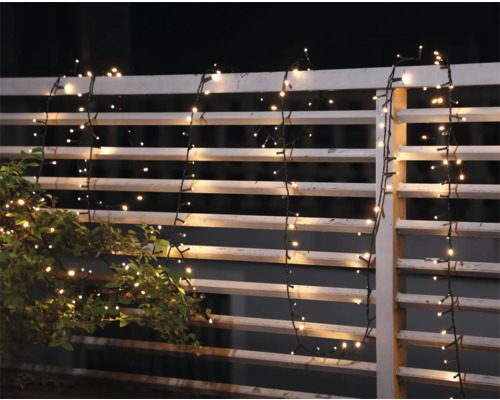 Guirlande lumineuse décorative sur une clôture de jardin