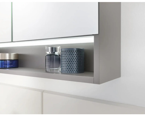 Detailansicht eines Spiegelschrankes mit Ablage und darauf platzierten Badutensilien