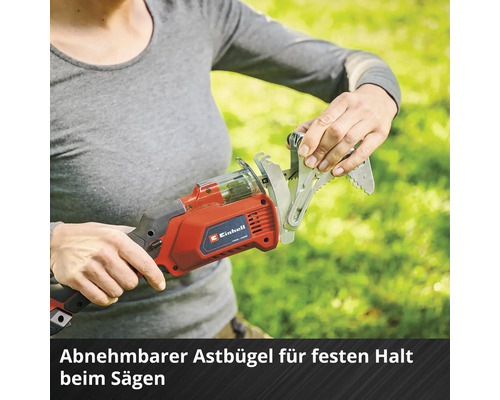 Une femme fixe un support de branche sur une scie à branches sans fil Einhell pour une prise ferme lors du sciage.