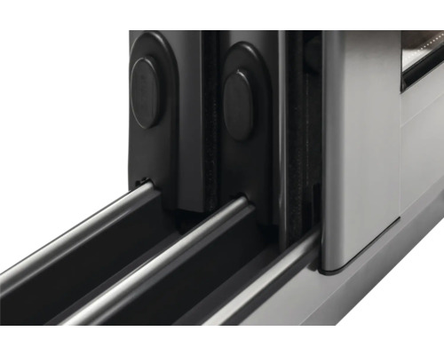 Gros plan sur une ferrure de porte coulissante avec rails de guidage.