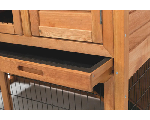 Detailansicht einer herausgezogenen Schublade aus einem Hasenstall aus Holz.