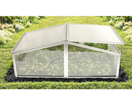 Serre châssis en plastique avec un couvercle ouvert dans le jardin.