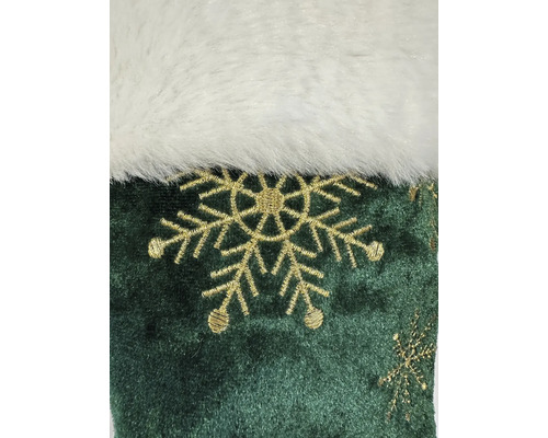 Detailaufnahme eines grünen Weihnachtsstiefels mit weißem Fellrand und Schneeflockenmuster