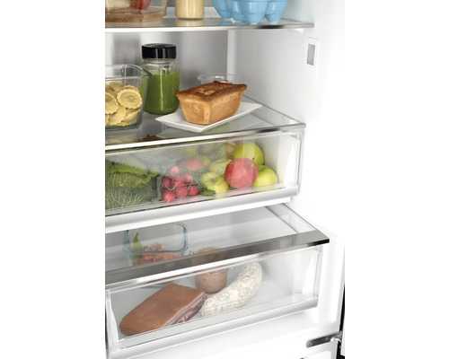 Innenansicht eines Kühlschranks mit Lebensmitteln wie Gemüse, Obst, Teigwaren und Fleischwaren.