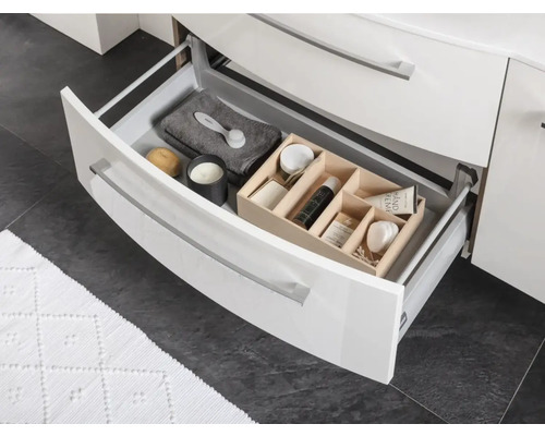 Offene Schublade mit Kosmetikartikeln im Badezimmerschrank