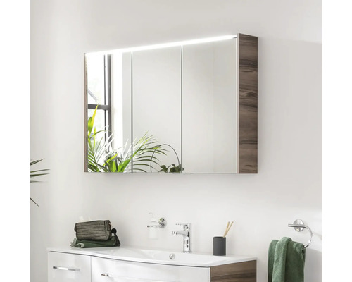 Spiegelschrank mit Beleuchtung über Waschbecken im Badezimmer