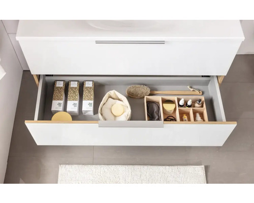 Tiroir ouvert d''un meuble de salle de bains avec des produits cosmétiques et des accessoires