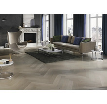 Salon avec canapé, fauteuil, cheminée et parquet en point de Hongrie