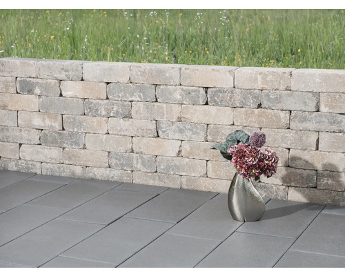 Gartenmauer aus Steinen mit Pflastersteinen und Blumenvase
