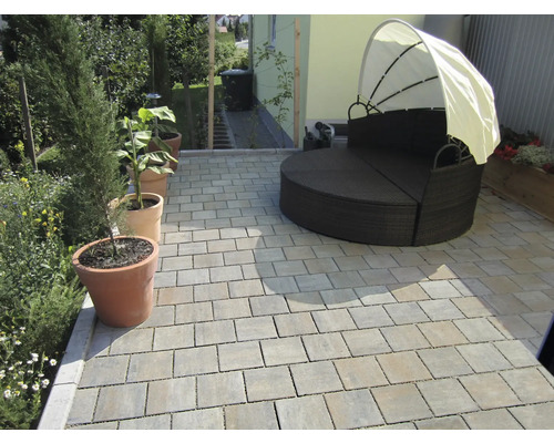 Terrasse avec pavés et lit de jardin rond avec protection solaire