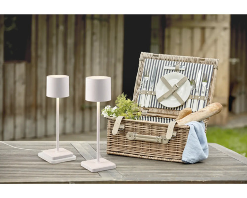 Scène avec deux lampes de table et un panier de pique-nique sur une table en bois