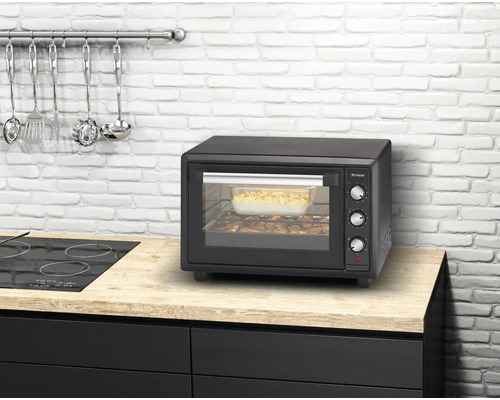 Four de cuisine compact sur un comptoir de cuisine avec des ustensiles