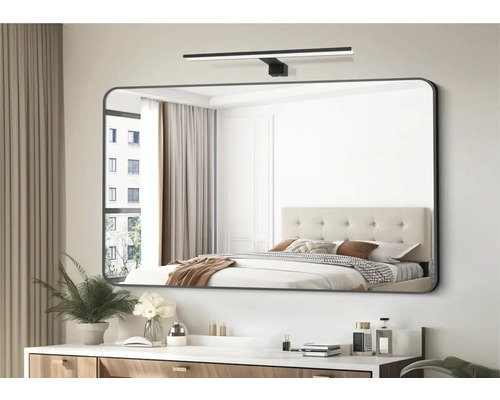 Miroir rectangulaire avec éclairage au-dessus d''une coiffeuse dans une chambre